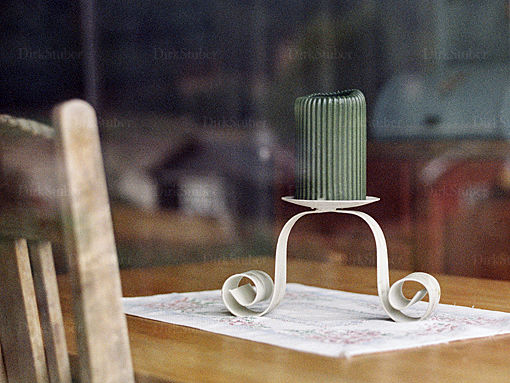 Blick durch ein Fenster auf einen Tisch mit einer Kerze